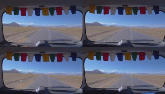 特写:透过一辆汽车的后窗，可以看到西藏一条空旷的道路。高清在线视频素材下载