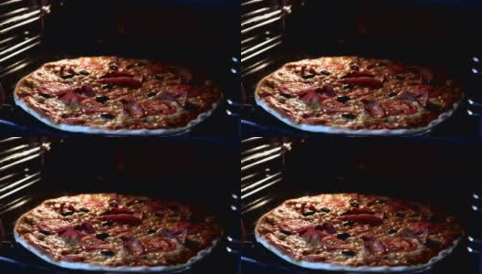 从烤箱内部看。用电热对流烤箱烹制意大利披萨。特写的披萨上面有西红柿，橄榄，马苏里拉火腿和奶酪。披萨奶酪融化冒泡。间隔拍摄。高清在线视频素材下载