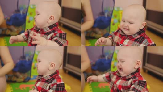 9个月大的婴儿穿着格子衬衫在家里哭闹。高清在线视频素材下载