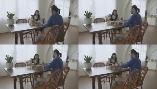 一对亚洲年轻夫妇在客厅的桌子上享受着外卖高清在线视频素材下载