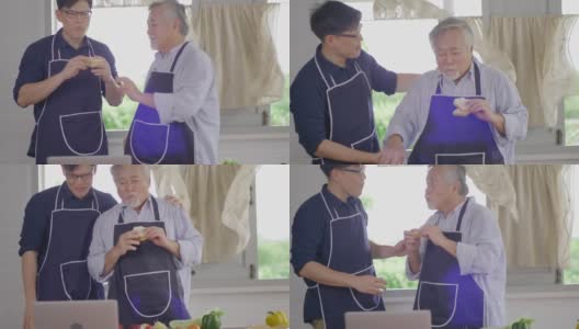 快乐的亚洲年轻人和老父亲在家里的厨房里一起准备美味健康的沙拉，享受周末高清在线视频素材下载