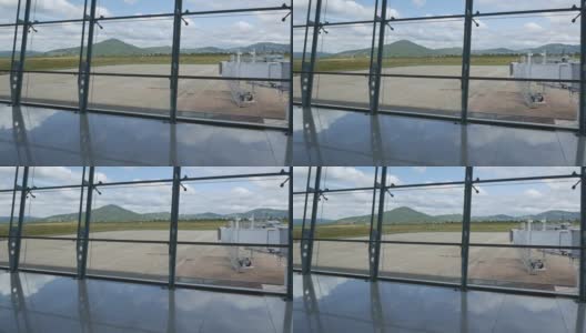 现代化的机场，通过窗口可以看到美丽的跑道和客运大楼。山的背景高清在线视频素材下载