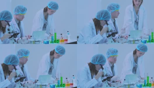 The group scientists research and uses a microscope in a laboratory.高清在线视频素材下载