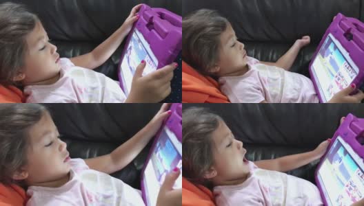 可爱的小女孩躺在平板电脑高清在线视频素材下载