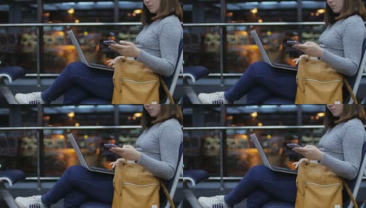 一名女子乘客在夜航离港机场触摸手机和使用笔记本电脑高清在线视频素材下载