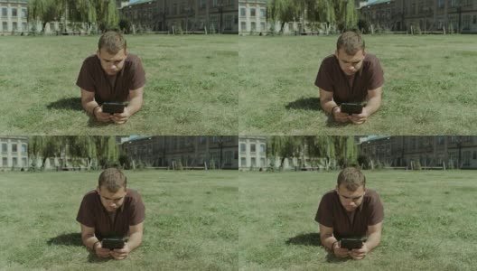 在校园草坪上使用平板电脑的大学生高清在线视频素材下载