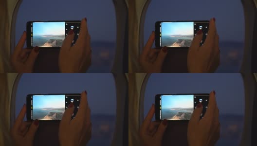 靠近拿着手机的女人，在飞机窗外拍照高清在线视频素材下载