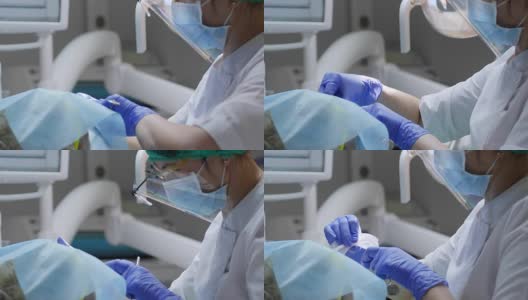 医务人员在牙科诊所用牙镜检查口腔疾病，脸上贴有消毒餐巾高清在线视频素材下载