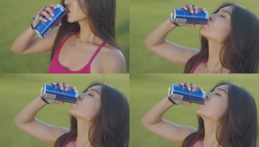 年轻女子喝能量饮料。亚洲女人喝汽水罐高清在线视频素材下载