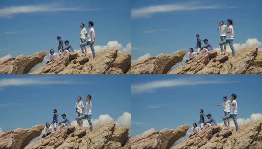年轻的亚洲成年男子站在海边的岩石上高清在线视频素材下载