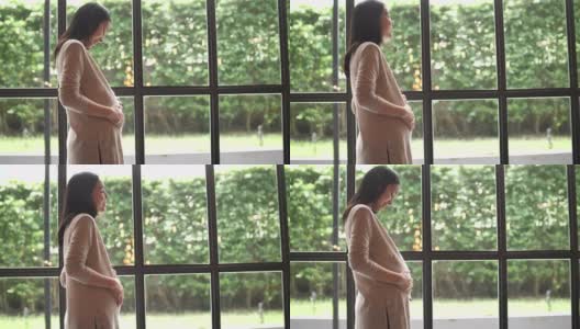 怀孕的亚洲妇女轻轻触摸她的肚子高清在线视频素材下载