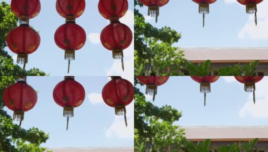 破旧建筑上的纸灯笼。阳光明媚的日子里，红色的纸灯笼悬挂在饱经风霜的混凝土庙宇建筑的天花板上。传统的装饰高清在线视频素材下载