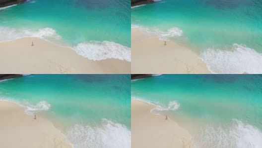 鸟瞰图的女人走在努沙佩尼达风景优美的海滩上高清在线视频素材下载