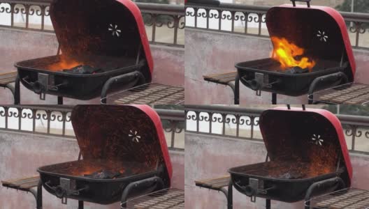 在4k的白天，用加压鼓风机在屋顶上吹出许多火花的木炭烤架的特写高清在线视频素材下载