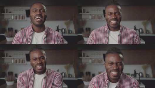 屋内激动的英俊黑人男子的肖像，带着富有感染力的笑声。高清在线视频素材下载