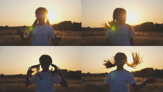 快乐的小女孩站在草地上玩着自己的头发，对着镜头。小微笑的女孩的肖像在草地上日落的背景。自由自在的概念。多莉拍摄高清在线视频素材下载