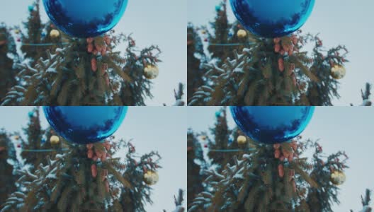 巨大的公共圣诞树上挂着玻璃玩具和松果高清在线视频素材下载