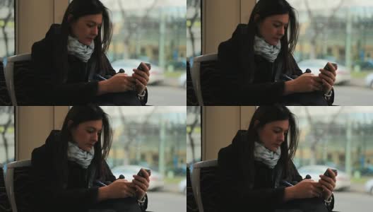 一名女子乘坐电车，在行驶的火车上看手机高清在线视频素材下载