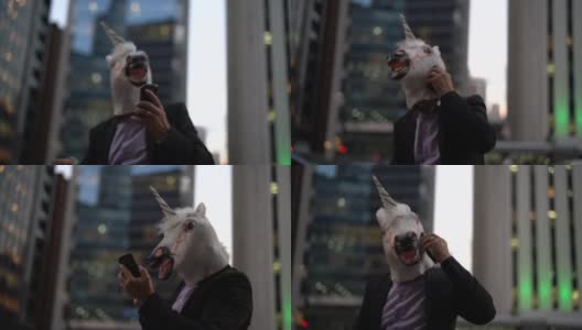 戴着独角兽面具的商人在城市里打电话高清在线视频素材下载
