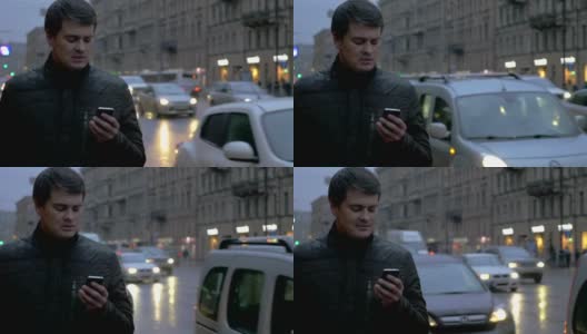 雨中的夜晚，男人拿着手机高清在线视频素材下载