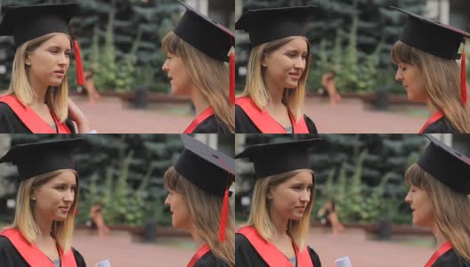 年轻漂亮的女人穿着学术服装在大学附近聊天，毕业典礼高清在线视频素材下载