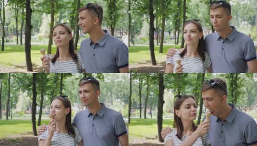 一对恩爱的情侣在公园里吃冰淇淋高清在线视频素材下载