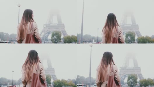 年轻时尚的女人走在巴黎市中心的背影，在法国的清晨浓雾和看埃菲尔铁塔高清在线视频素材下载