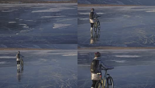 一个女人在冰上骑自行车。这个女孩穿着银色的羽绒服，背着自行车背包，戴着头盔。结冰的贝加尔湖的冰。自行车的轮胎上覆盖着特殊的尖钉。高清在线视频素材下载