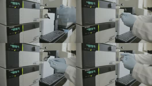 这是一位研究人员在大学基因实验室检查高效液相色谱(HPLC)的手持镜头高清在线视频素材下载