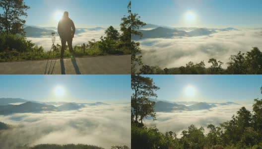 空中男性摄影师站在山上，举起他的手在早晨的日出高清在线视频素材下载