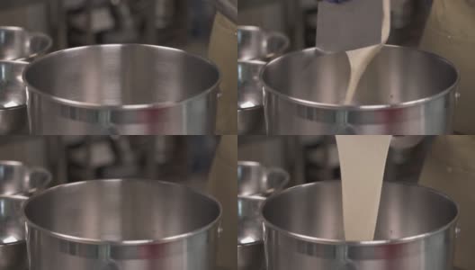 一个高度专业的面包师使用刮刀将面团放在碗里的特写演示视频。面团在批量发酵中静息和发酵。高清在线视频素材下载