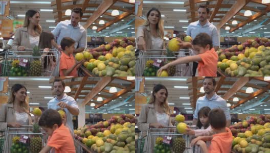 快乐的拉丁美洲家庭在超市购买杂货，孩子们选择水果加入购物车高清在线视频素材下载