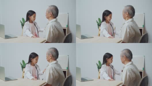 泰国可爱的女孩玩是医生检查一个老男人病人使用听诊器在家高清在线视频素材下载