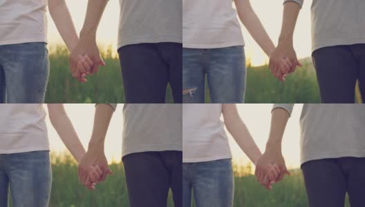 近距离拍摄的一对亚洲男人和女人站在一起，牵着对方的手，然后在美丽的夕阳下慢慢摇摆。蜜月约会的概念。高清在线视频素材下载