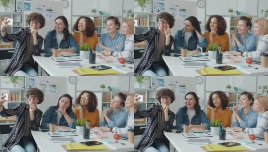 慢镜头:欢快的女性群体在工作中为智能手机自拍高清在线视频素材下载