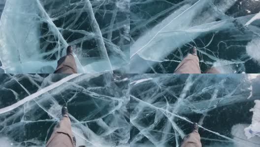 一个男人走在结冰的贝加尔湖上，湖面上有蓝色透明的冰，上面有很深的裂缝。高清在线视频素材下载