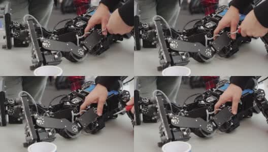 一个年轻的发明家工程师在修理他的机器人高清在线视频素材下载