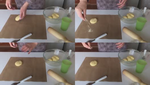 一个妇女用玉米面做无酵面包。将面团分成小块，撒上面粉，放在不粘的垫子上。高清在线视频素材下载