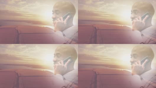 动画的微笑的非洲裔美国人使用智能手机在日落风景高清在线视频素材下载