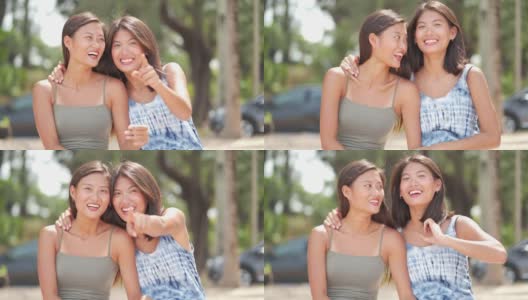微笑的亚洲妇女兄弟姐妹坐在阳光灿烂的海滩上的肖像高清在线视频素材下载