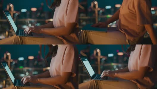 一个年轻女人的手在城市之夜用笔记本电脑高清在线视频素材下载