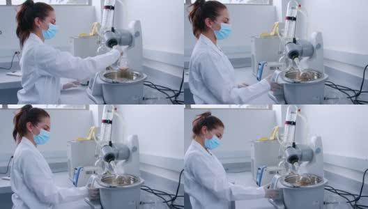 实验室的女研究员在调整机器中的样本高清在线视频素材下载