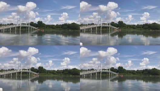 湛蓝的天空和湖上的桥，人们在夏天玩独木舟高清在线视频素材下载