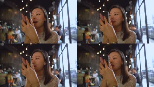 年轻的亚洲女性用智能手机涂口红高清在线视频素材下载