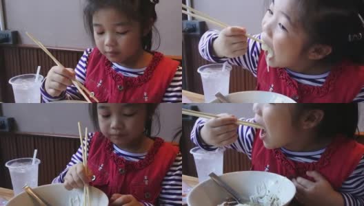 两个亚洲小孩在餐厅吃饭。高清在线视频素材下载
