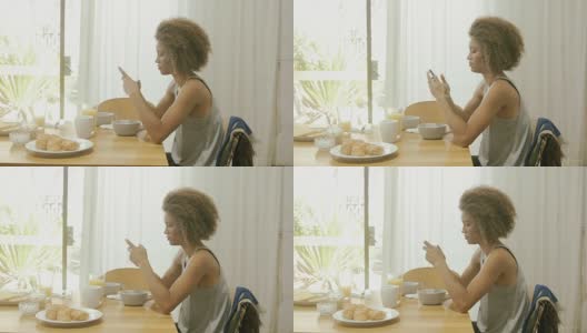 在早餐桌上用智能手机的美女高清在线视频素材下载