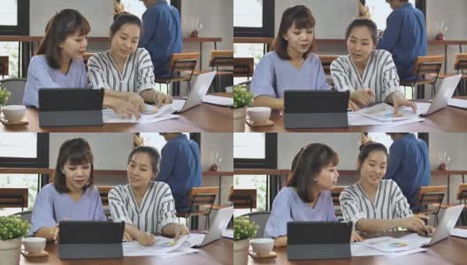 两个女性朋友在咖啡店里看电子平板电脑高清在线视频素材下载