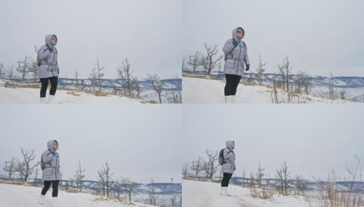 女人在贝加尔湖冰面上的旅行。闭关独特的佛塔布尔可汗纪念碑象征神秘的历史仪式岛大井山水山萨满教崇拜。冬岛之旅。高清在线视频素材下载