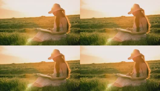 女孩在日落时读着关于乡村风景的书高清在线视频素材下载