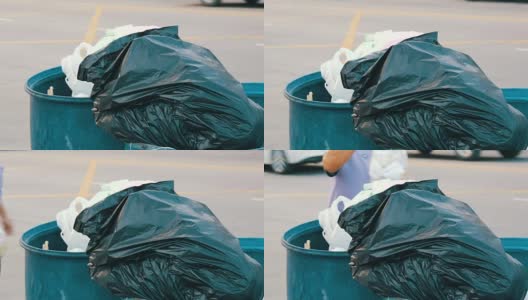 一位上了年纪的妇女把一整包垃圾扔进了垃圾桶高清在线视频素材下载